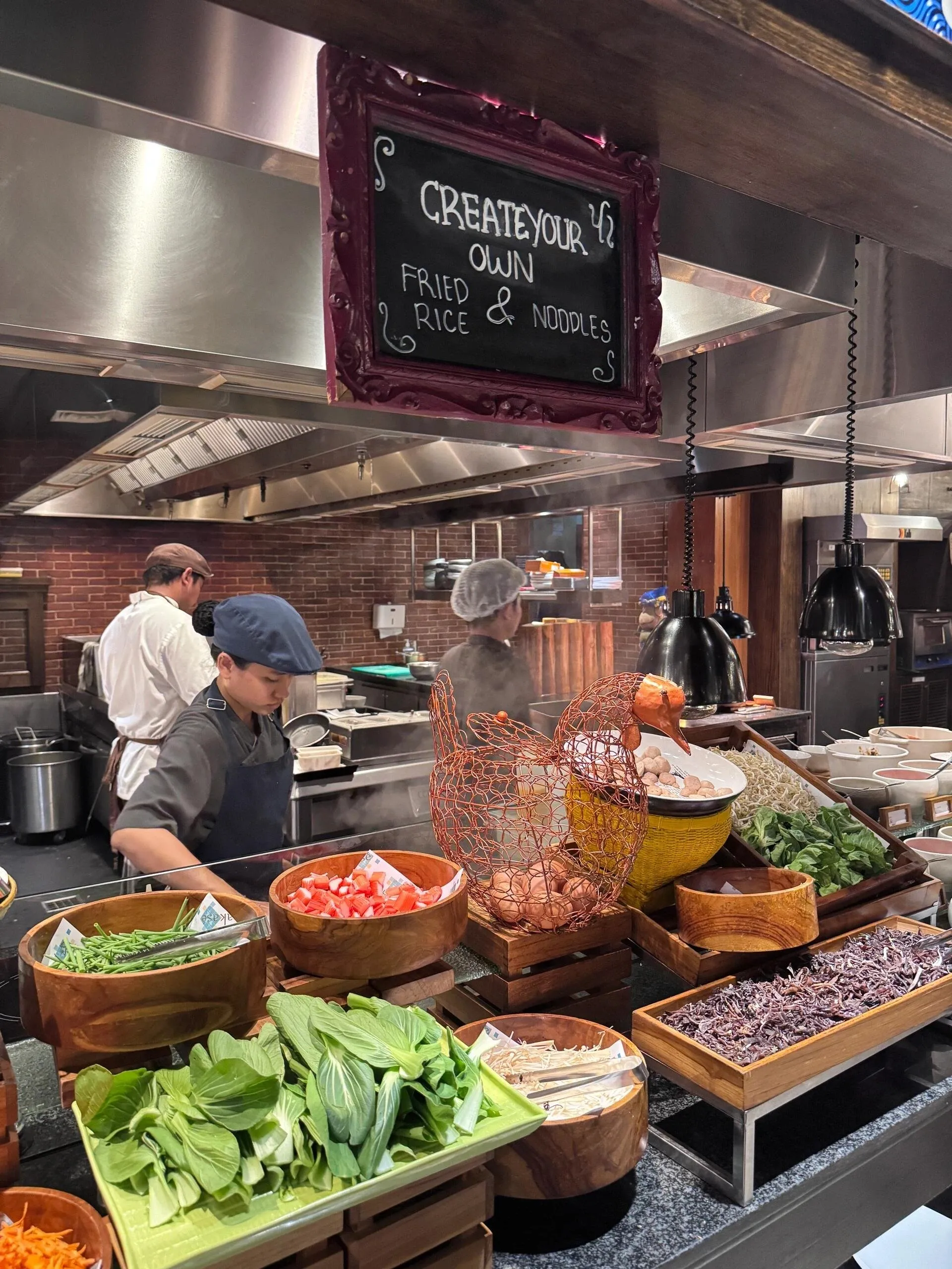 The breakfast buffet’s create-your-own fried rice and noodles station, with chefs cooking behind bowls of greens and eggs