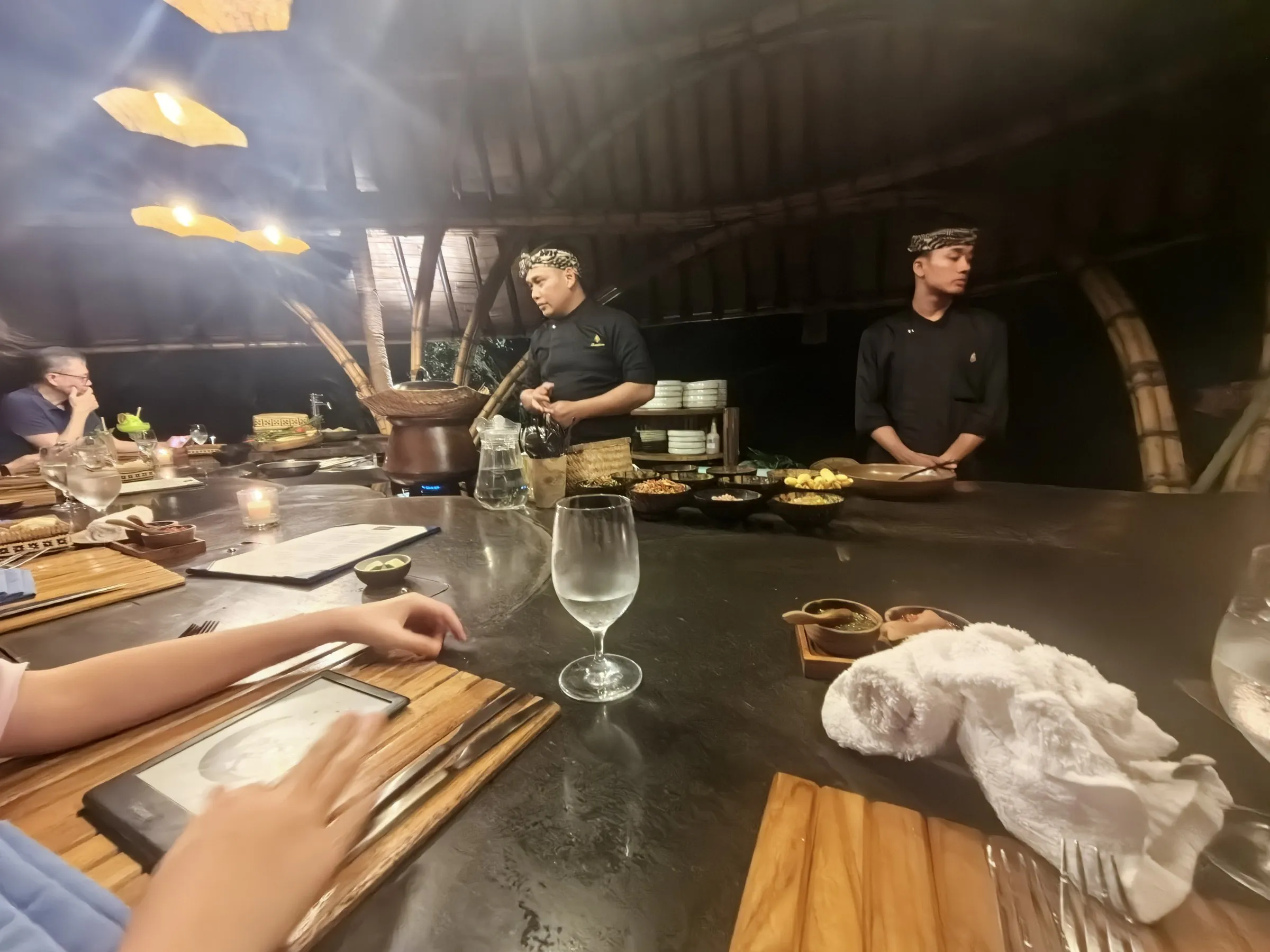 Two chefs cooking behind a dark counter at a chef’s table dinner