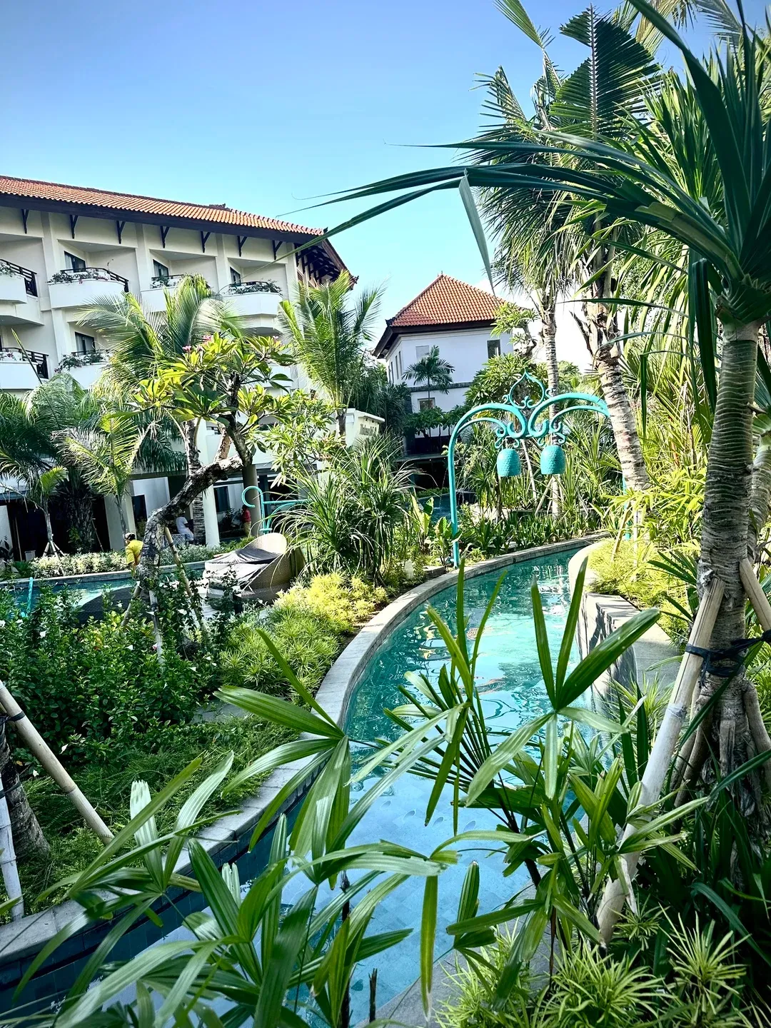 The lazy river winding through tropical planting between the guest wings