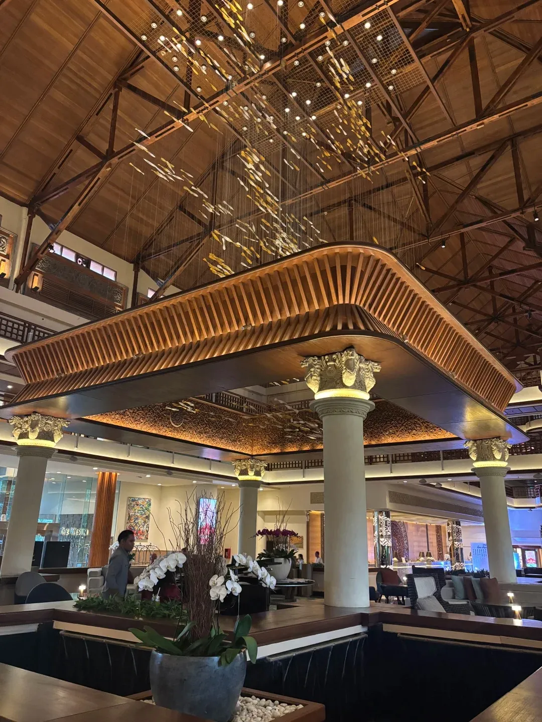 The lobby lounge under a soaring timber roof and chandelier