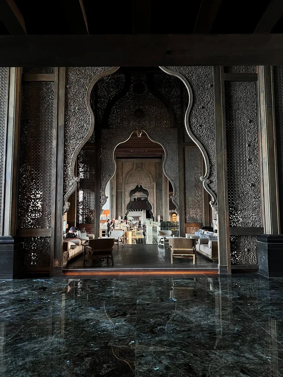 Carved stone archways opening onto the lobby lounge over polished marble