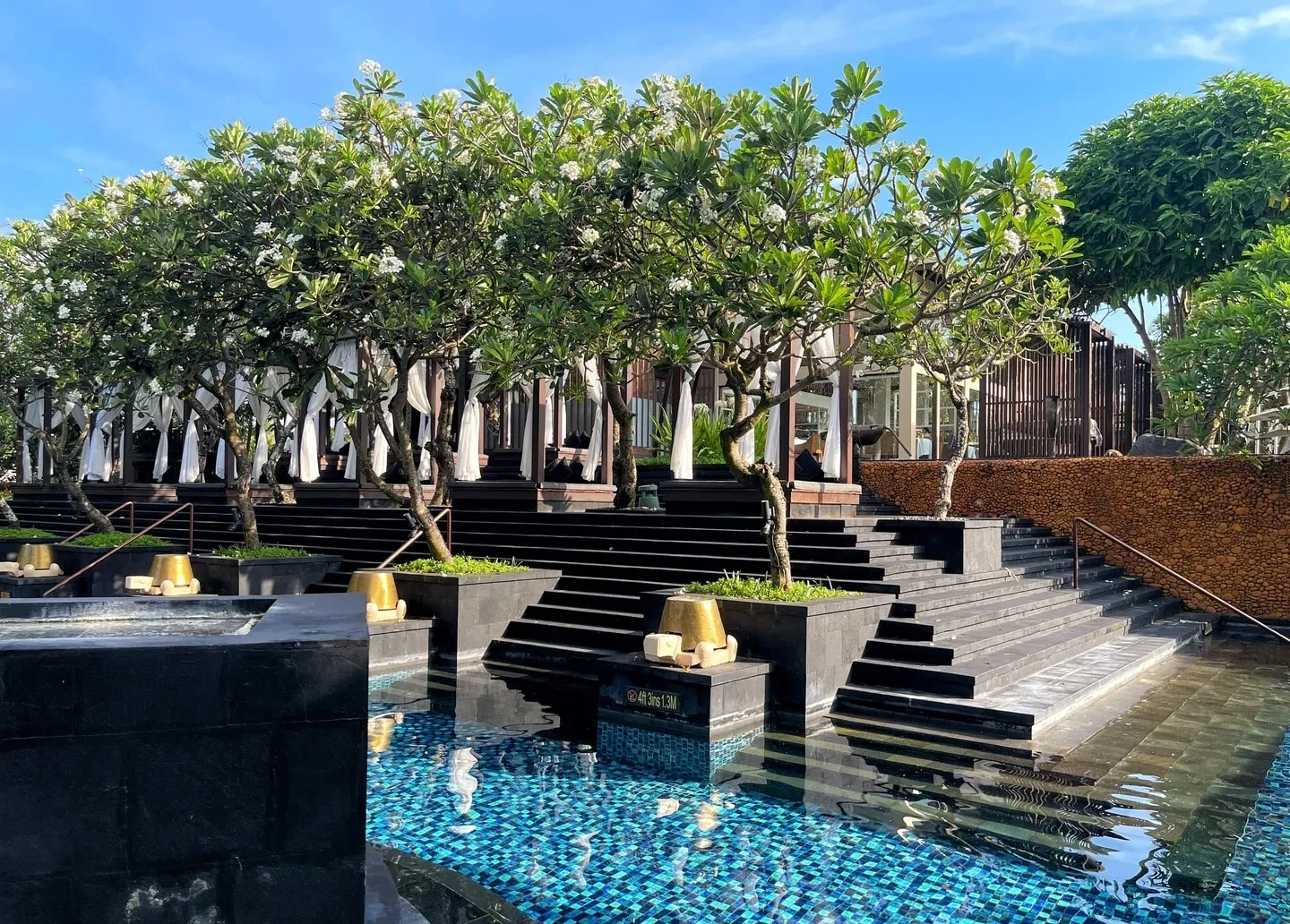 Wide stone steps leading down into a reflecting pool by the lobby
