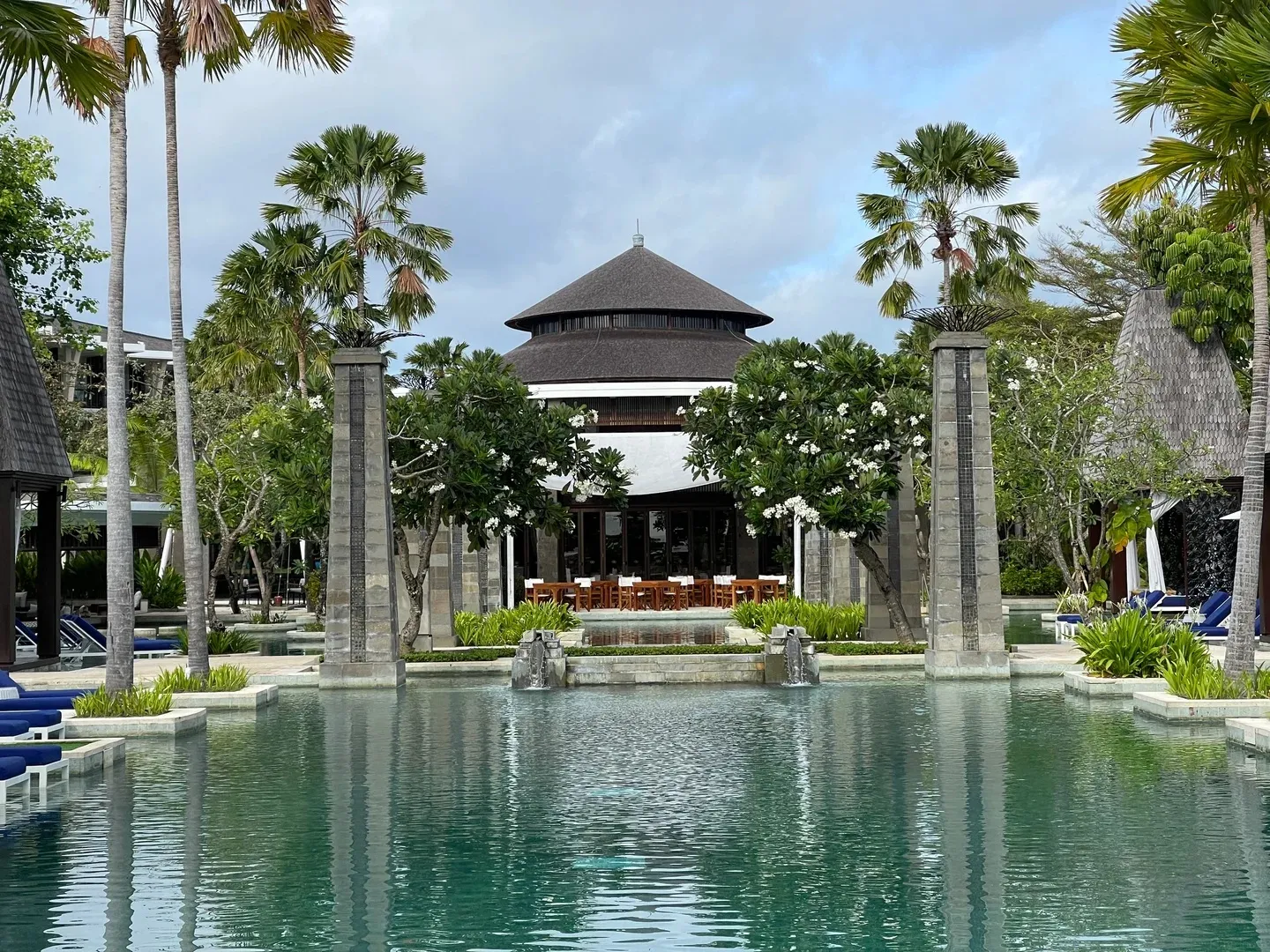 The main pool in front of a pavilion with a peaked thatched roof