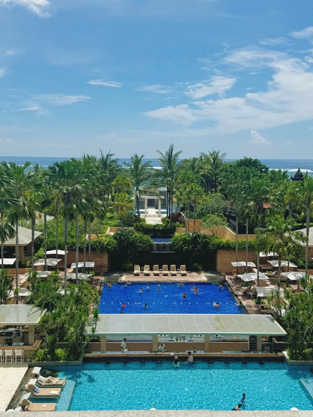 The tiered pools and gardens seen from above, with the sea behind