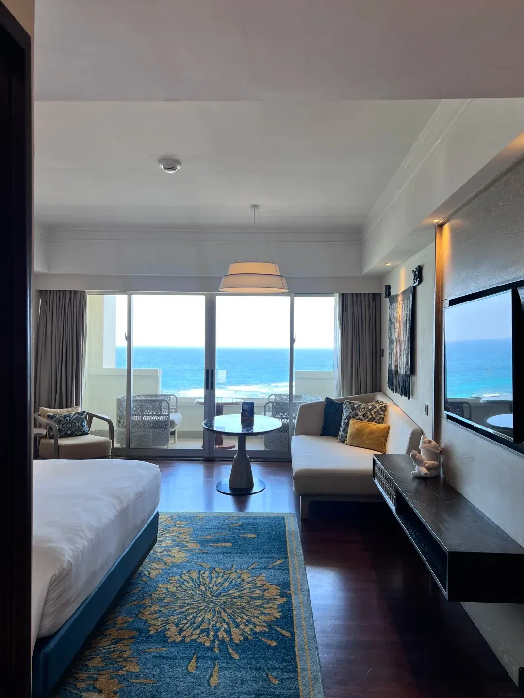 A Hilton sea-view room with a king bed and a sofa facing the balcony