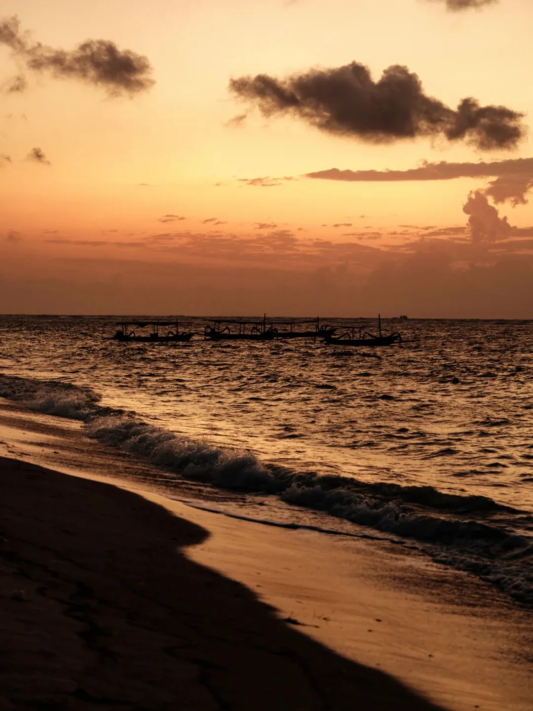 Sunrise over the sea with fishing boats on the horizon
